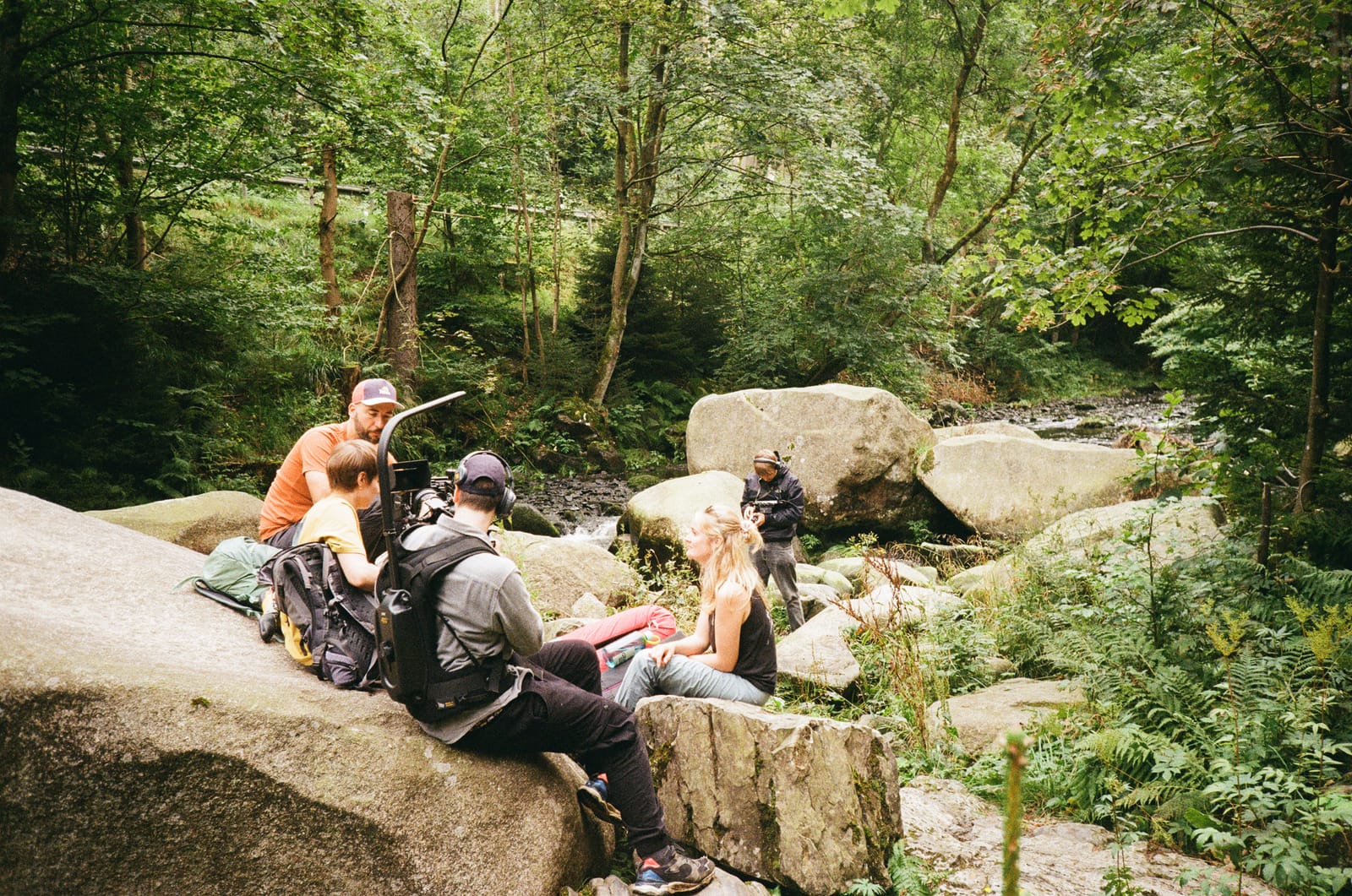 Crew taking a break on the boulders of a forest stream