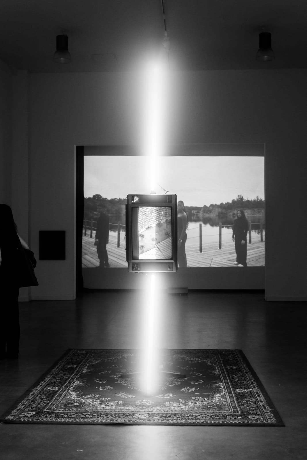 A shaft of light through a video installation in front of a projection