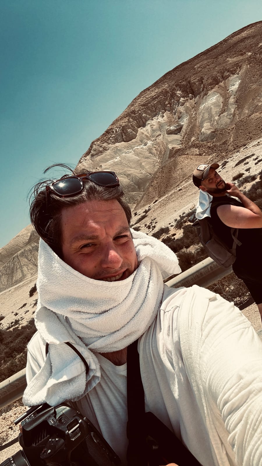 Selfie in the desert heat, towel around the neck, crew member behind