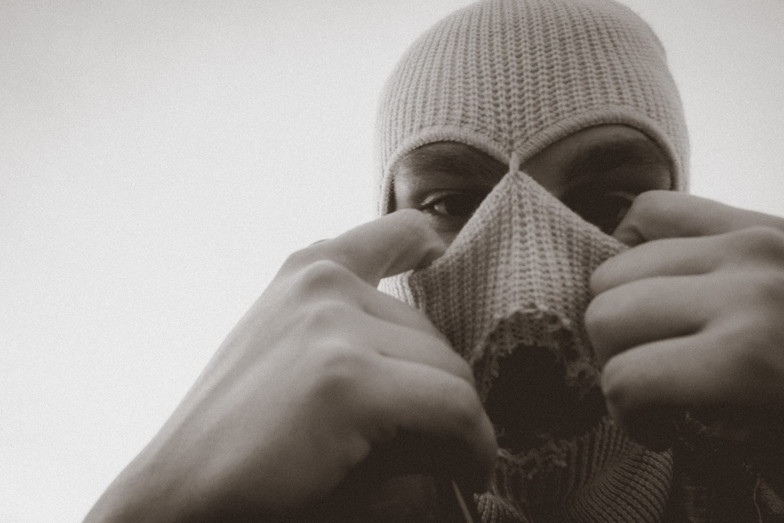 Close portrait of a man pulling up a knitted balaclava