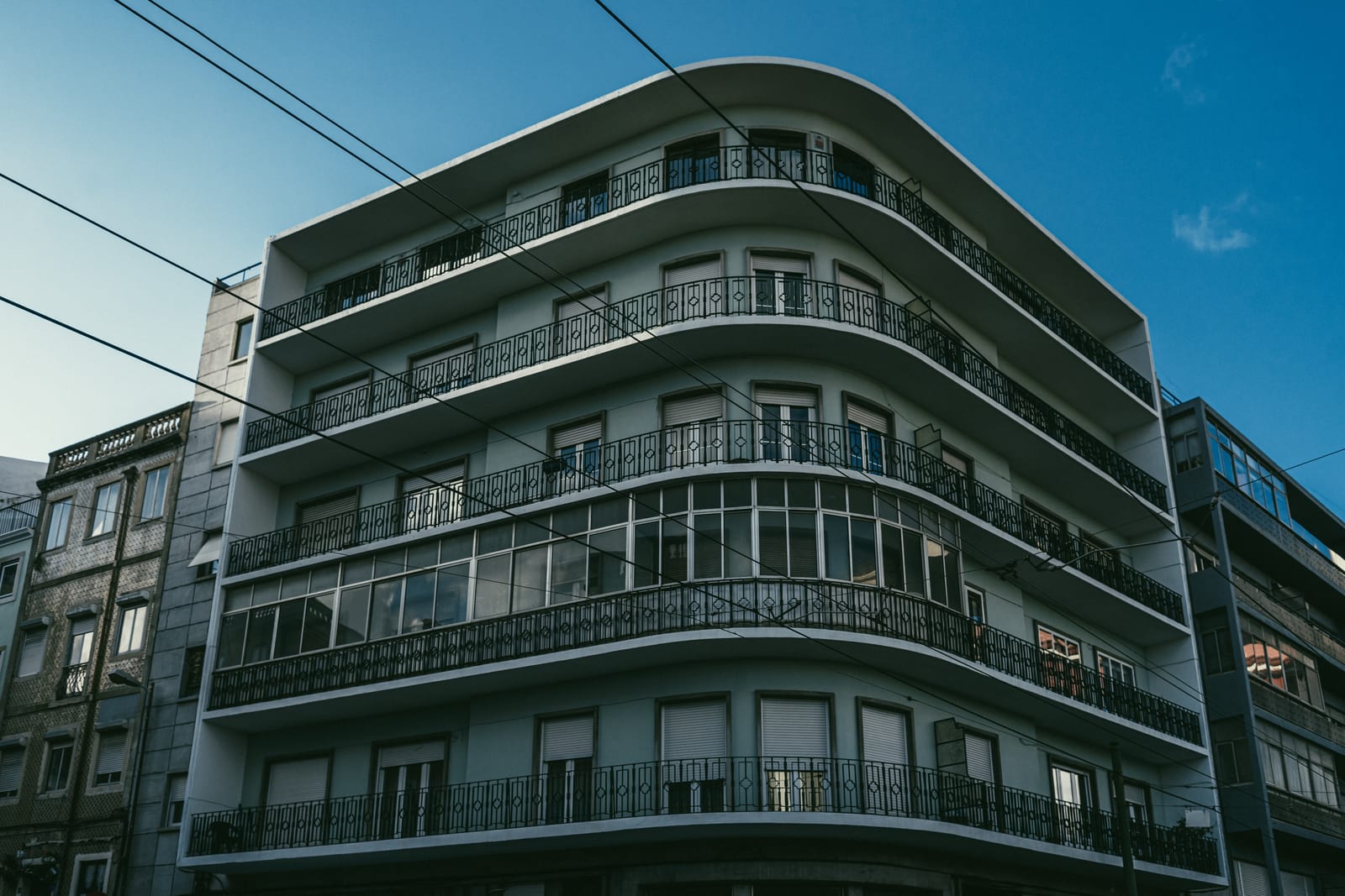 Curved balconies of an apartment block against a blue evening sky