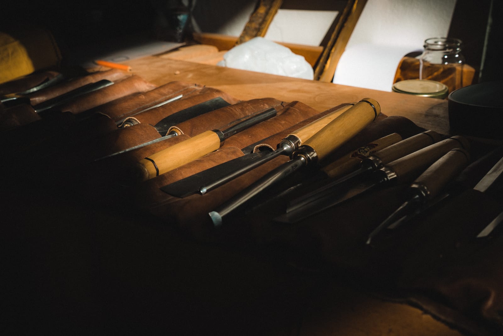 Carving tools laid out on a wooden workbench