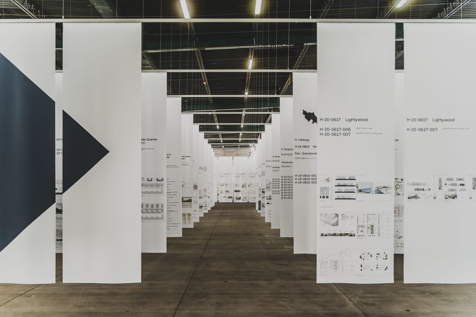Aisle between hanging white panels in a large exhibition hall