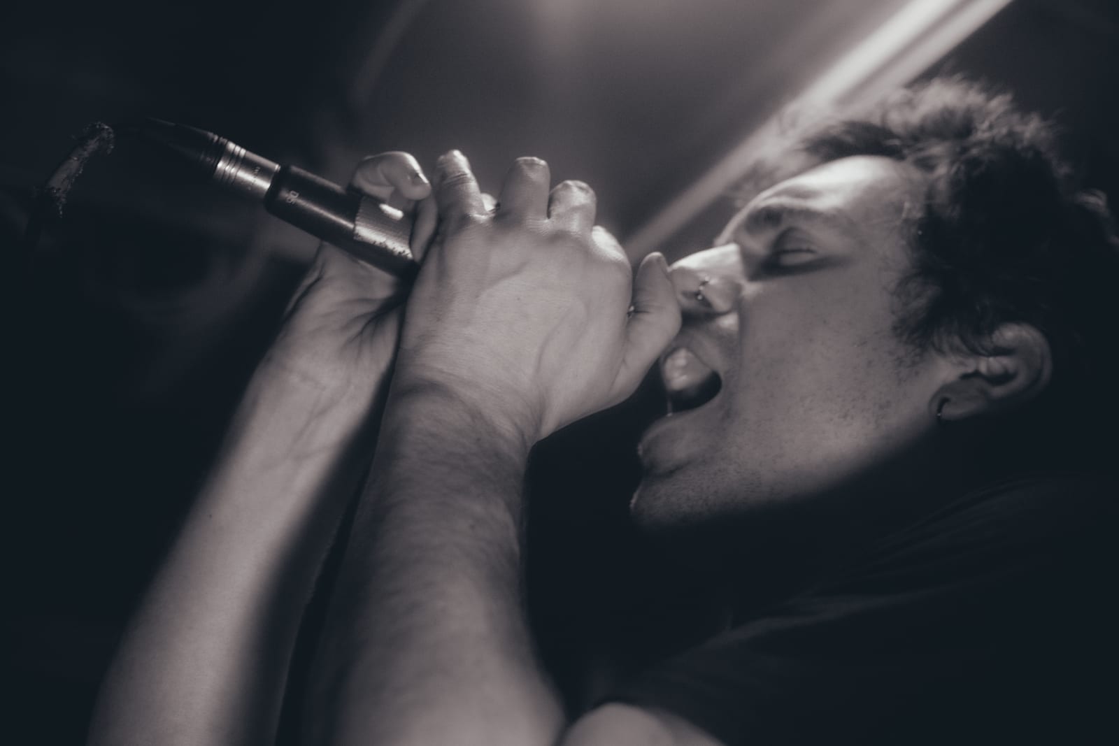 Singer gripping a microphone, in black and white