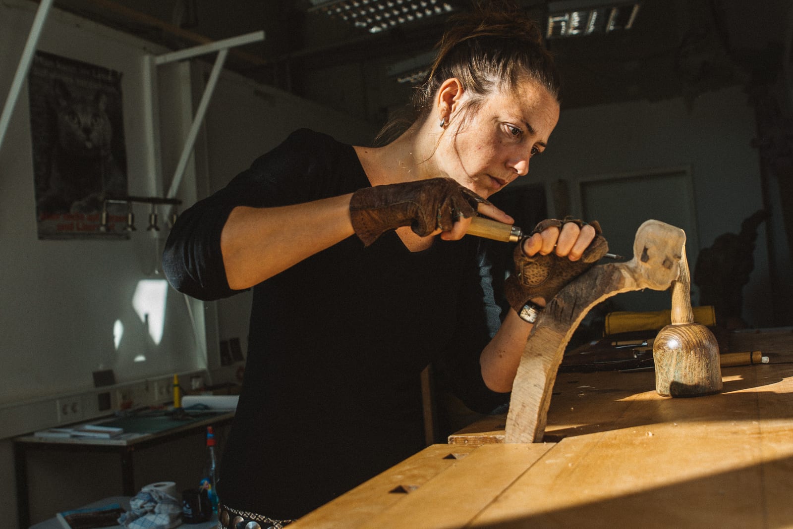 Craftswoman carving wood at a workbench